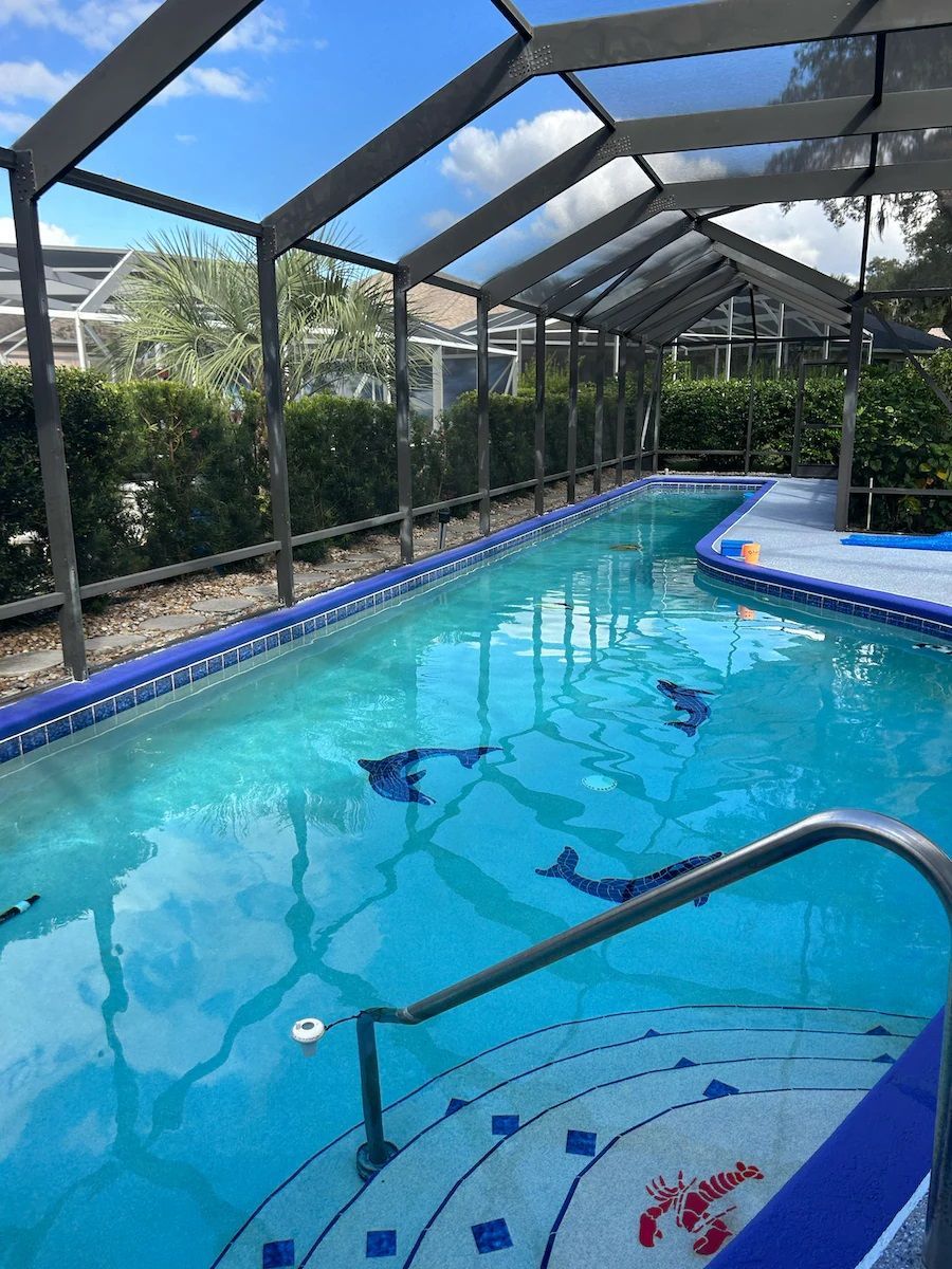 A large swimming pool with dolphins on the bottom of it