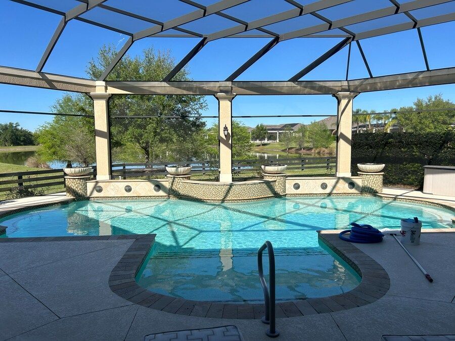 A large swimming pool with a screened in area surrounding it