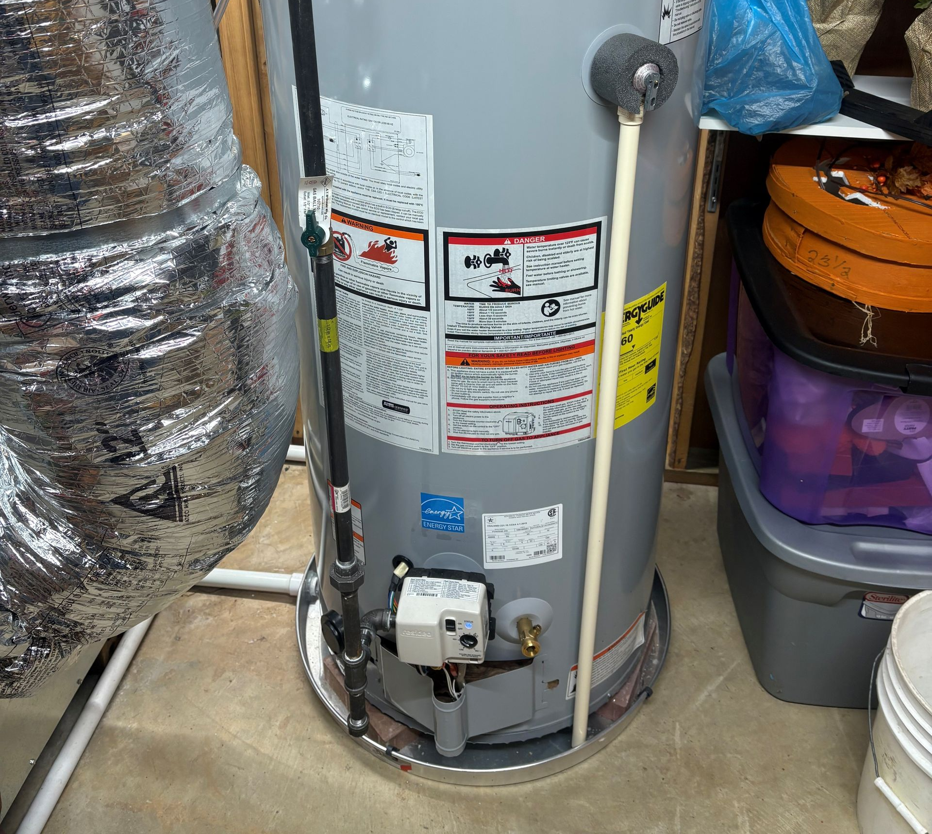 A person repairs a heating system; they are holding a tool and working on the internal components.