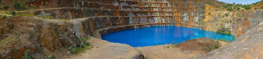 A deep blue lake surrounded by tiered, rocky cliffs.