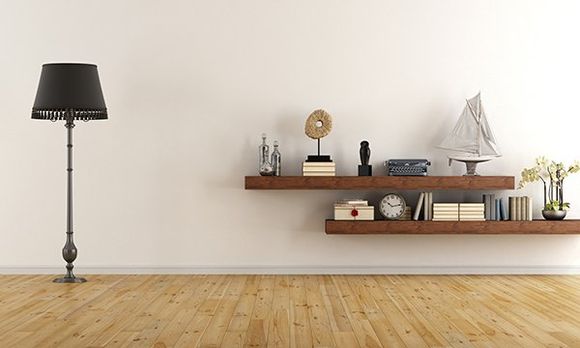 A white wall with shelves and a lamp.