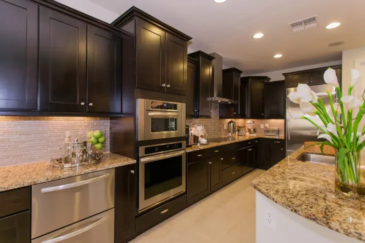 Three copper pipes are connected to each other on a wall.