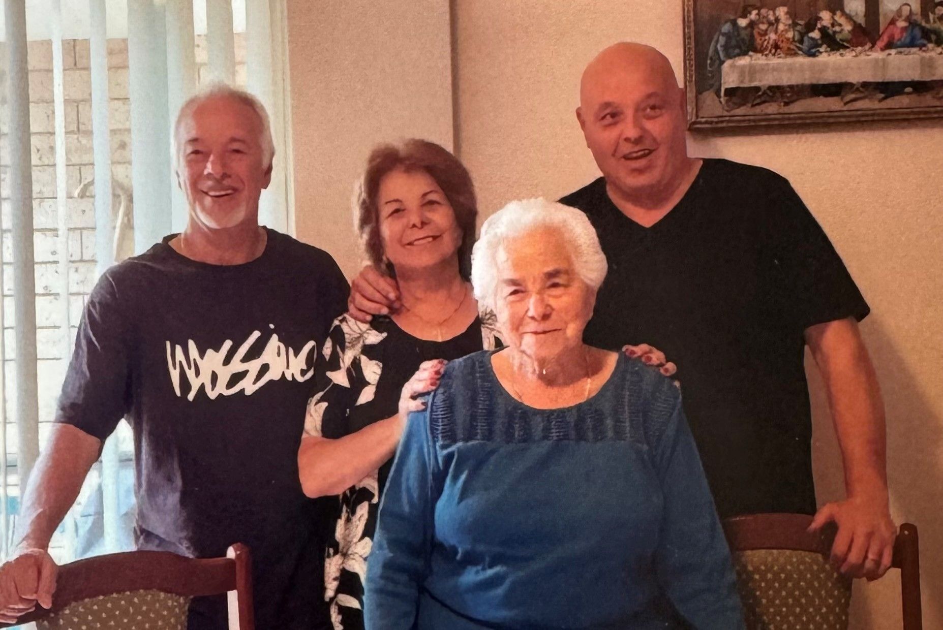 4 people posing together indoors, smiling. 