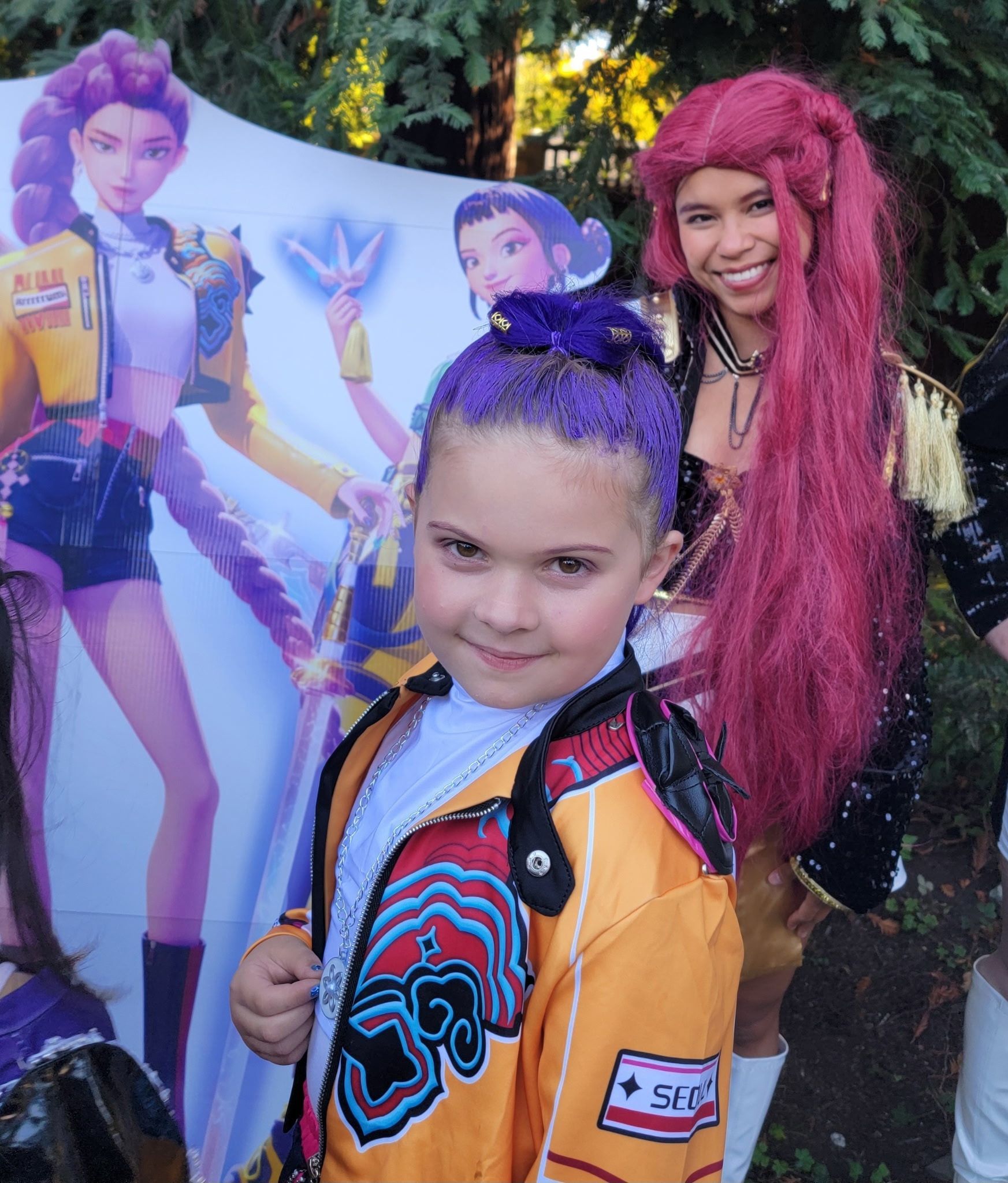 Young girl with short brown hair and a maroon shirt smiles in a salon chair.