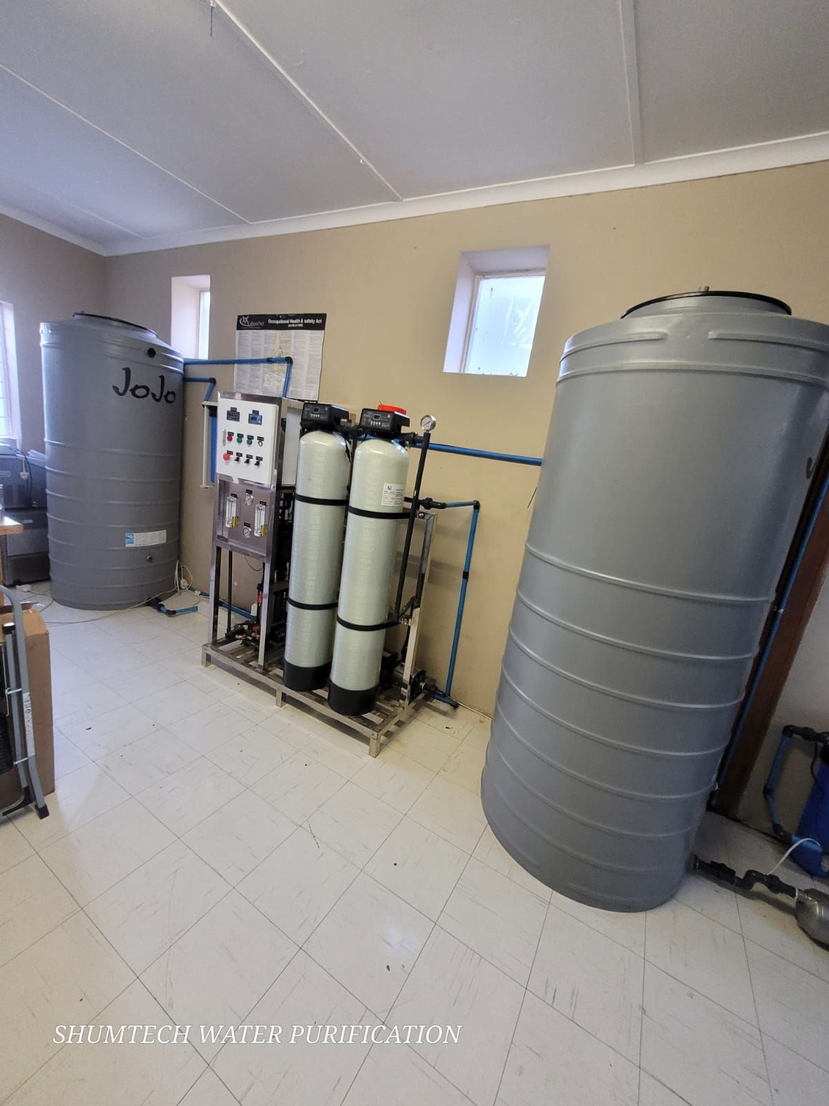A room with a lot of water tanks and a water filter.