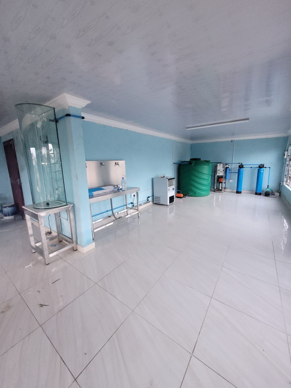 A large room with blue walls and white tile floors.