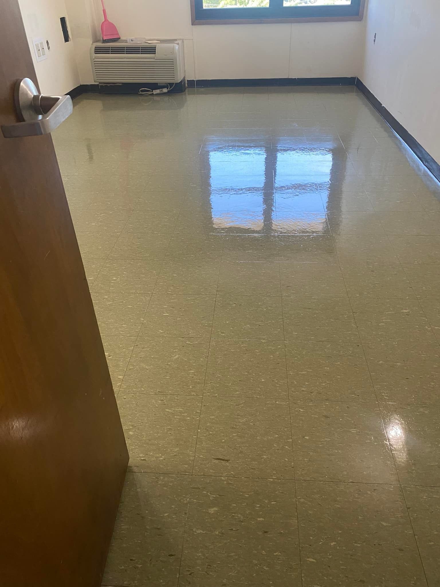 A room with a shiny floor and a window.