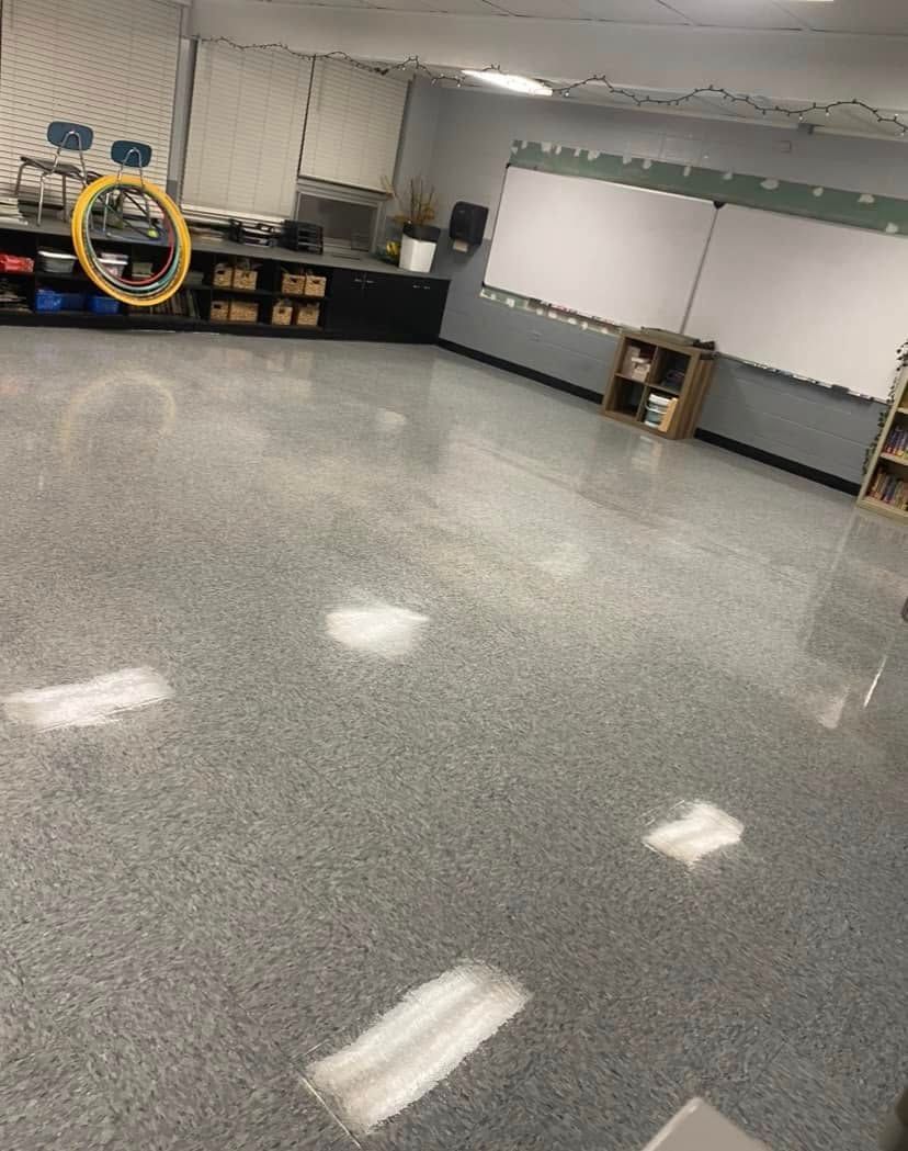 A classroom with a gray floor and a white board.