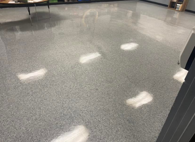 A room with a gray floor and white lights on it.