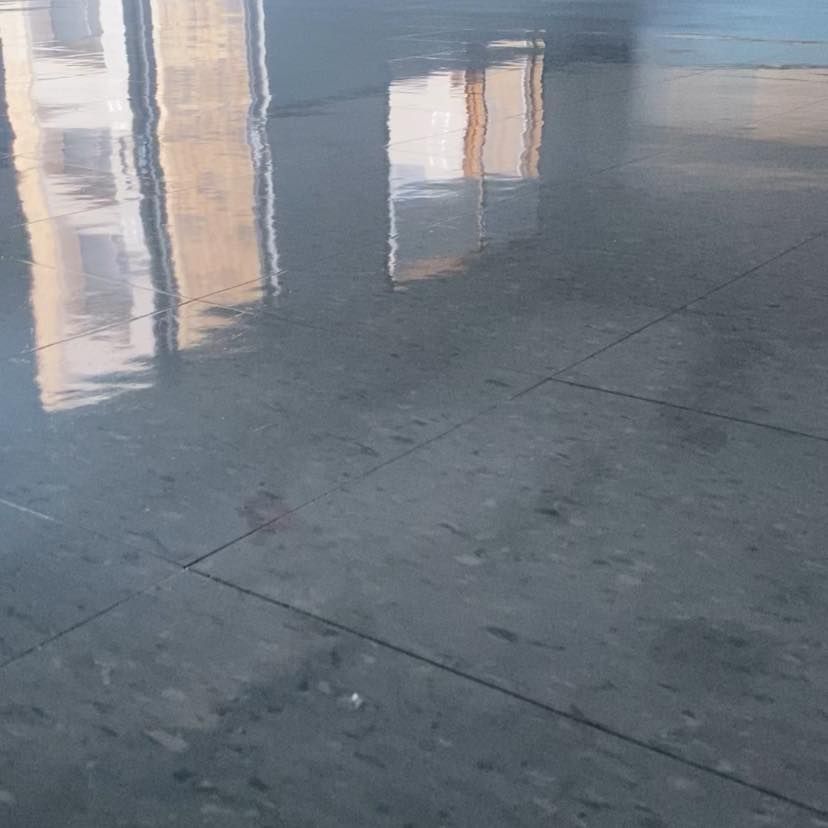 A close up of a tiled floor with a reflection of a building.