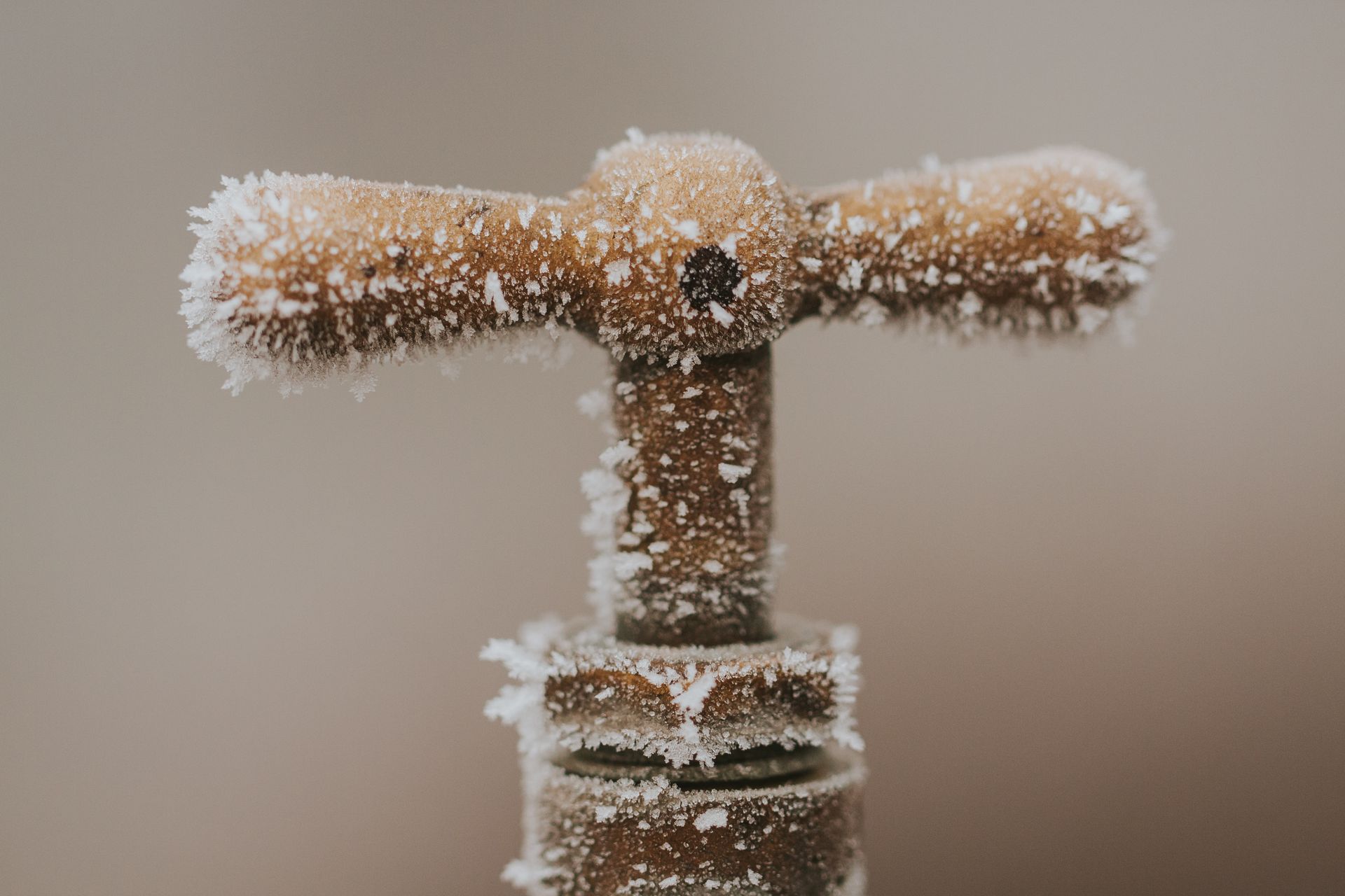 A close up of a faucet with frost on it.
