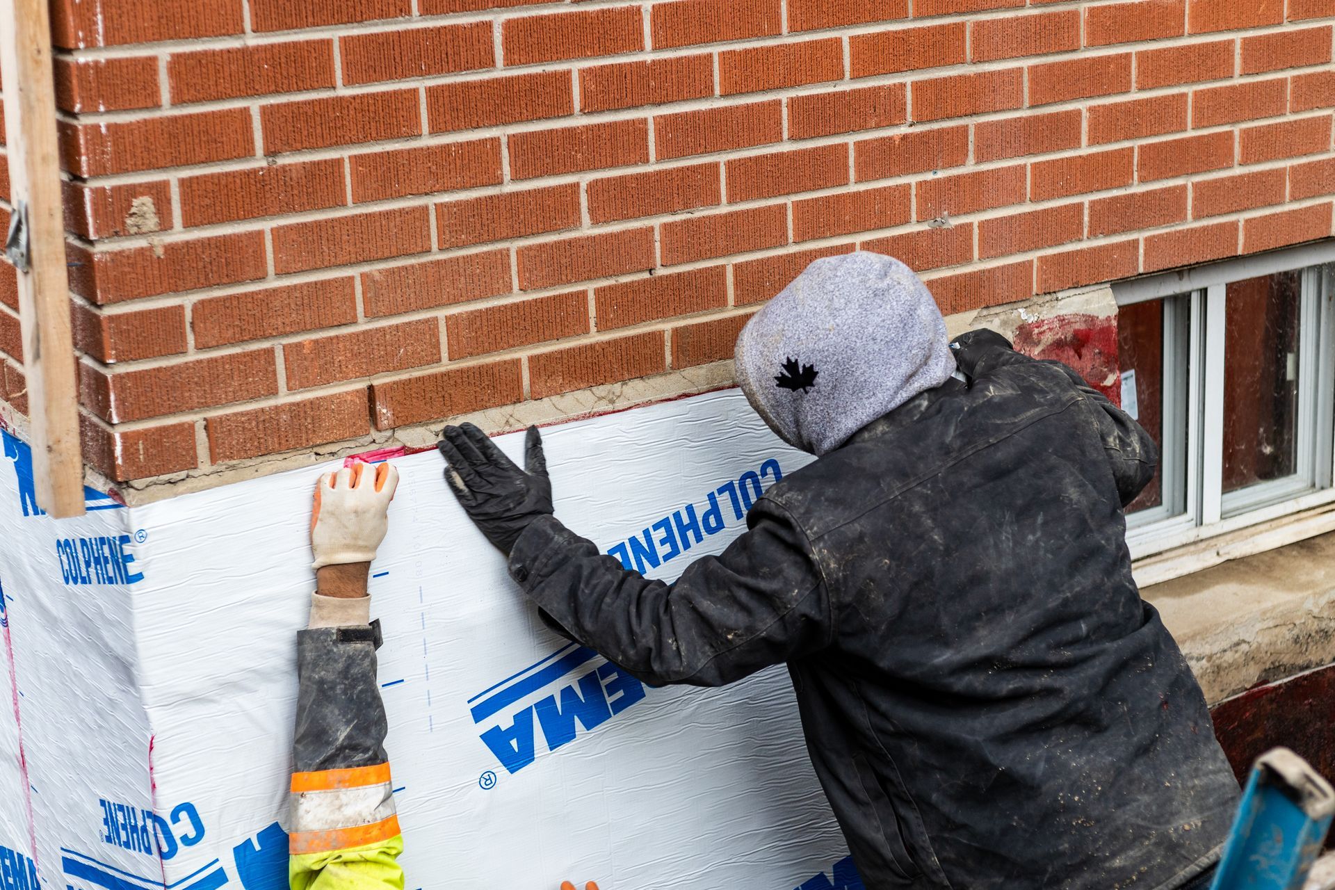 A roll of roofing material , tools , and gloves on the ground.