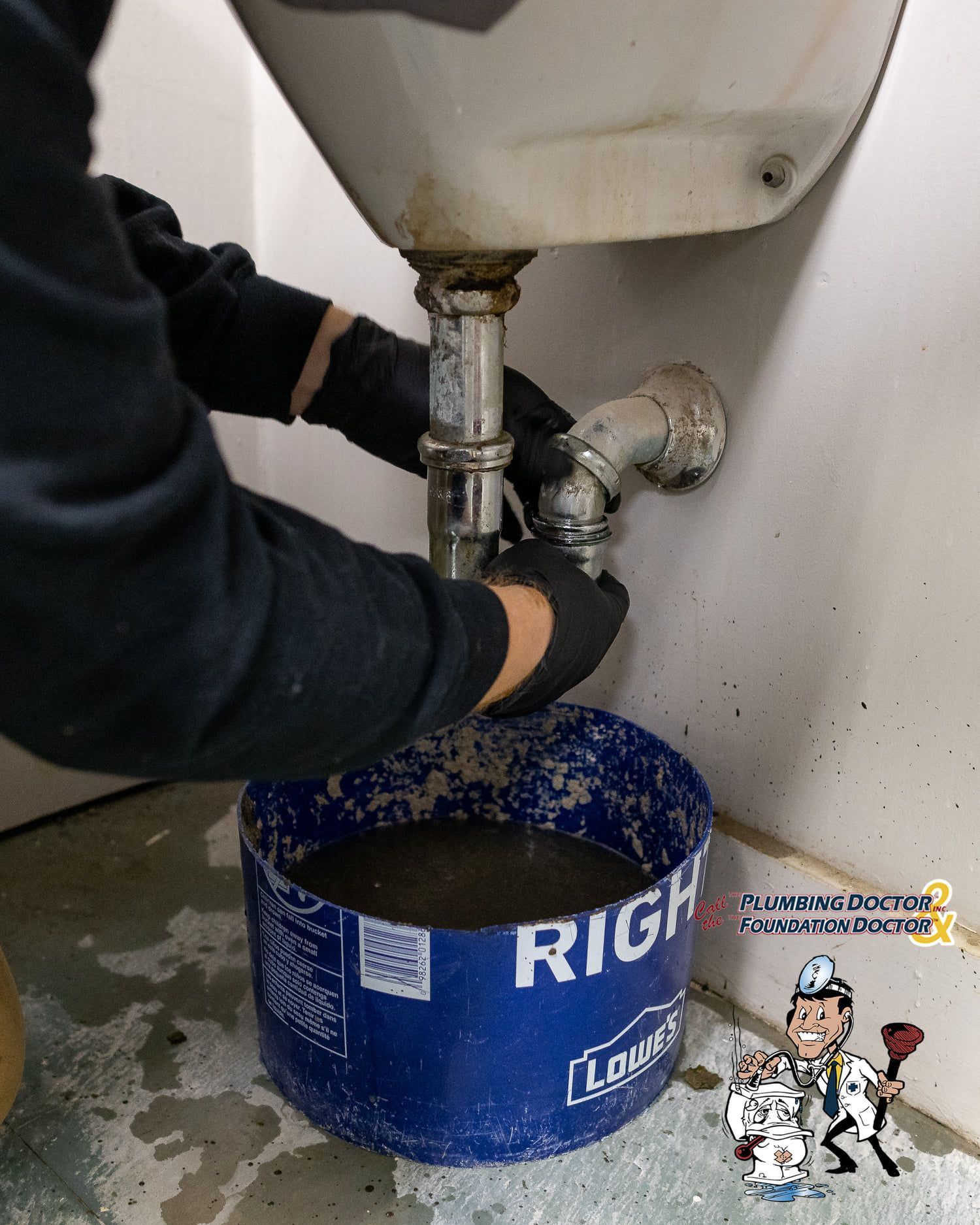 A man is using a plunger to fix a sink