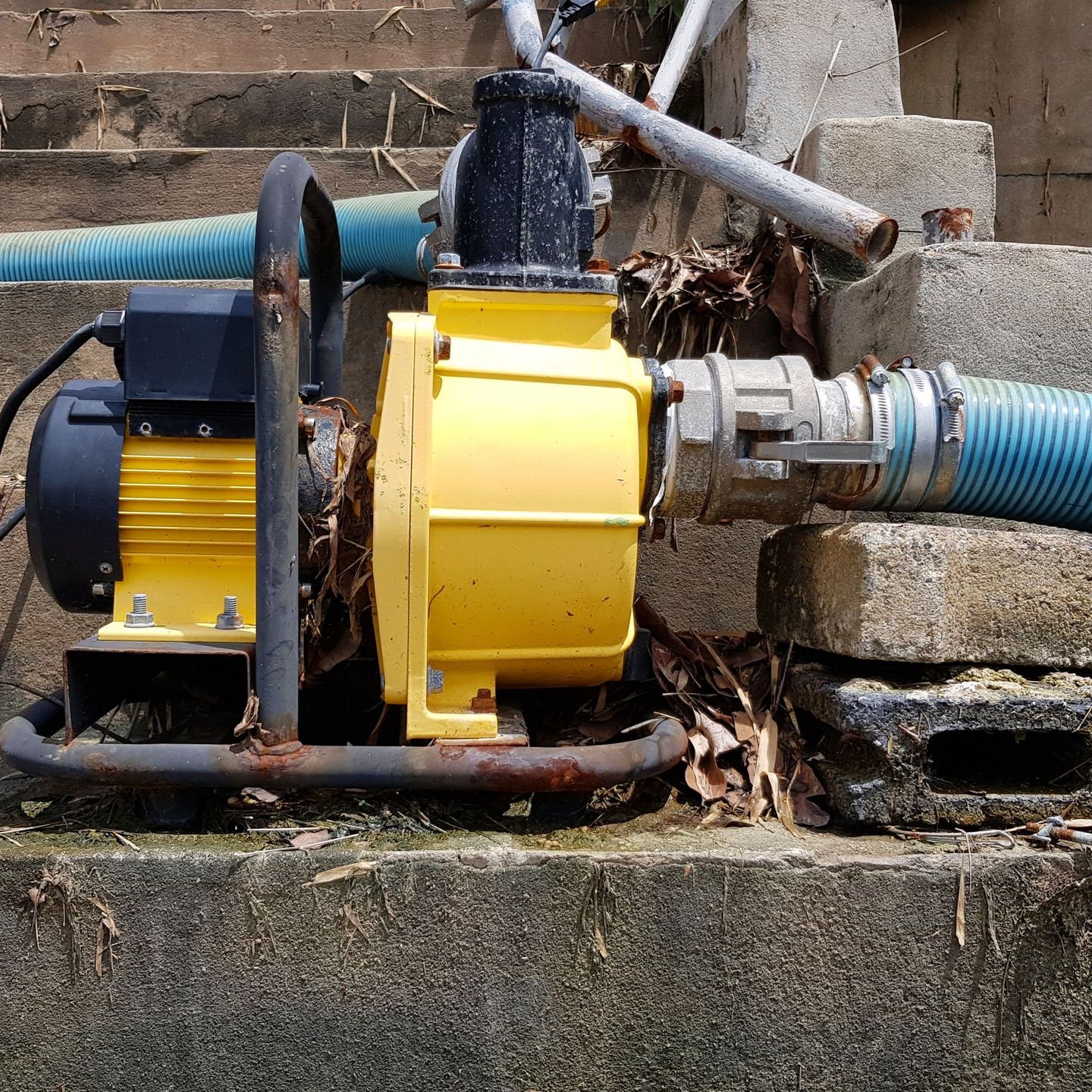 A yellow pump with a blue hose attached to it