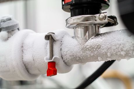 A close up of a pipe covered in snow and ice.