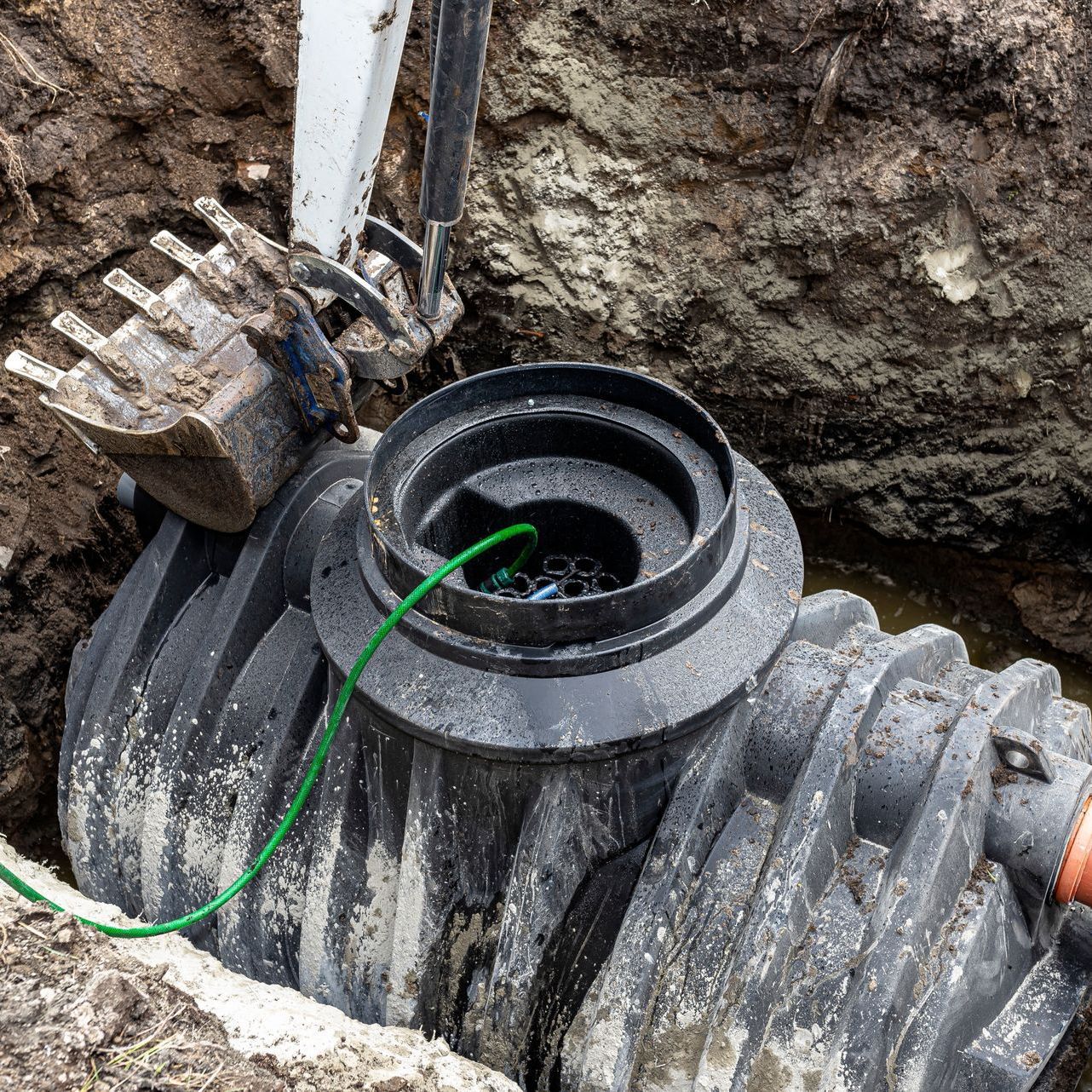 A septic tank is being installed in a hole in the ground.