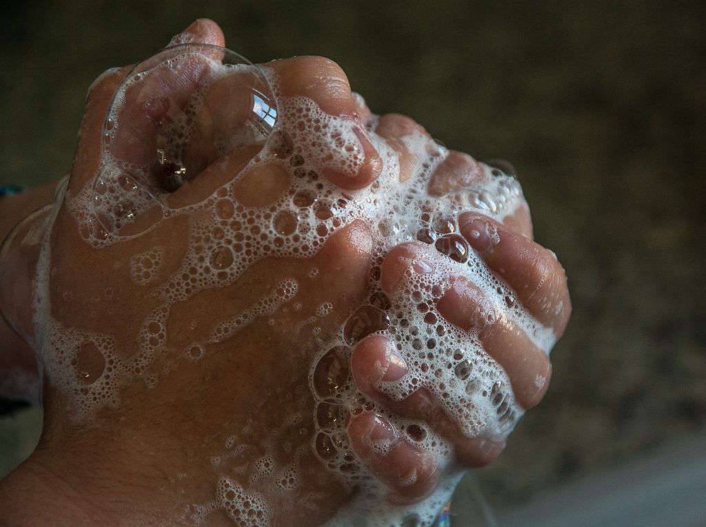 A person is washing their hands with soap and water.