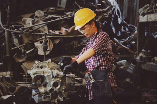 Lady using wrench in a factory