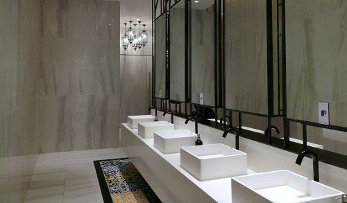 A bathroom with a row of sinks and mirrors.