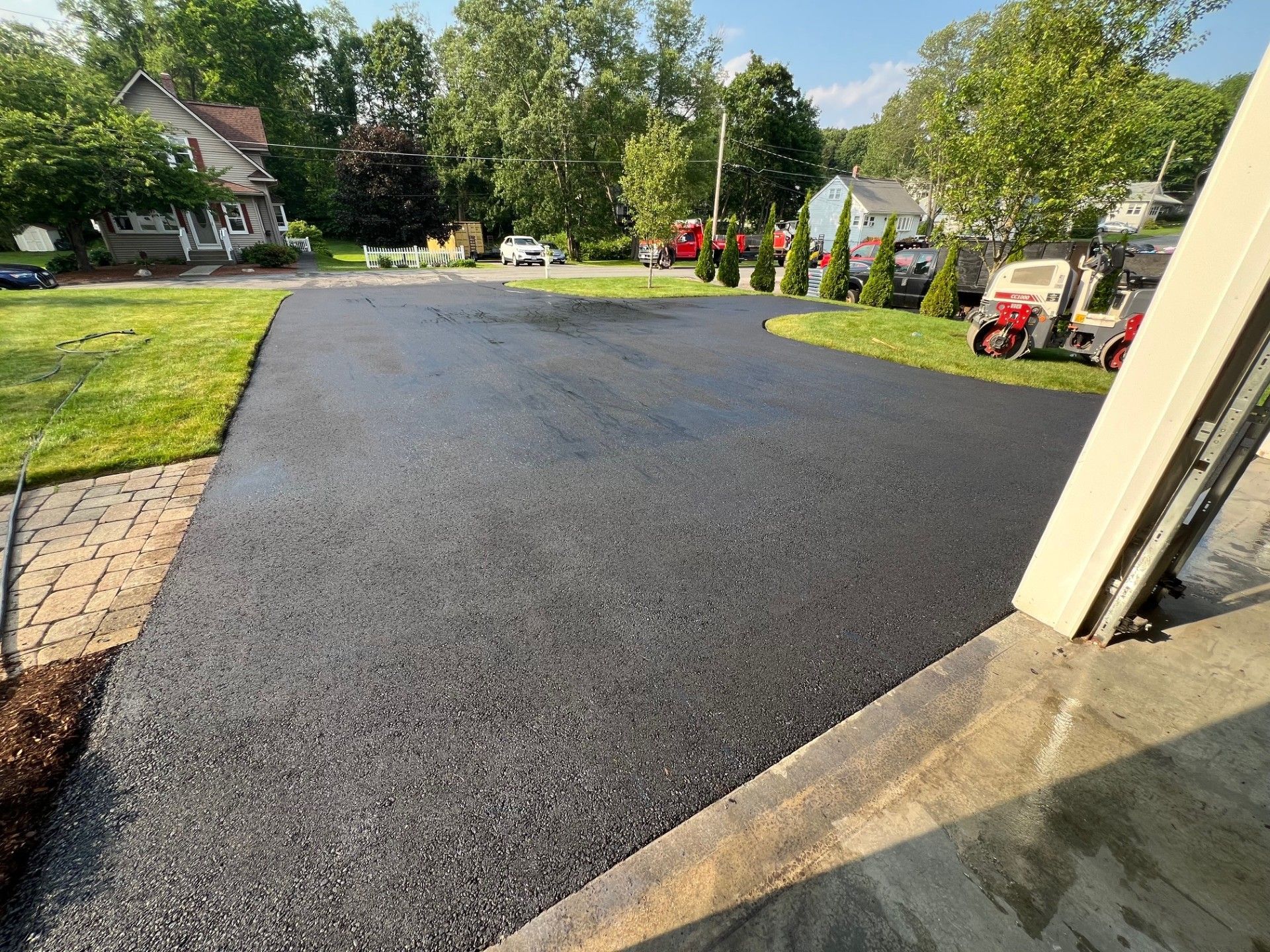 Newly paved asphalt driveway in front of a house.
