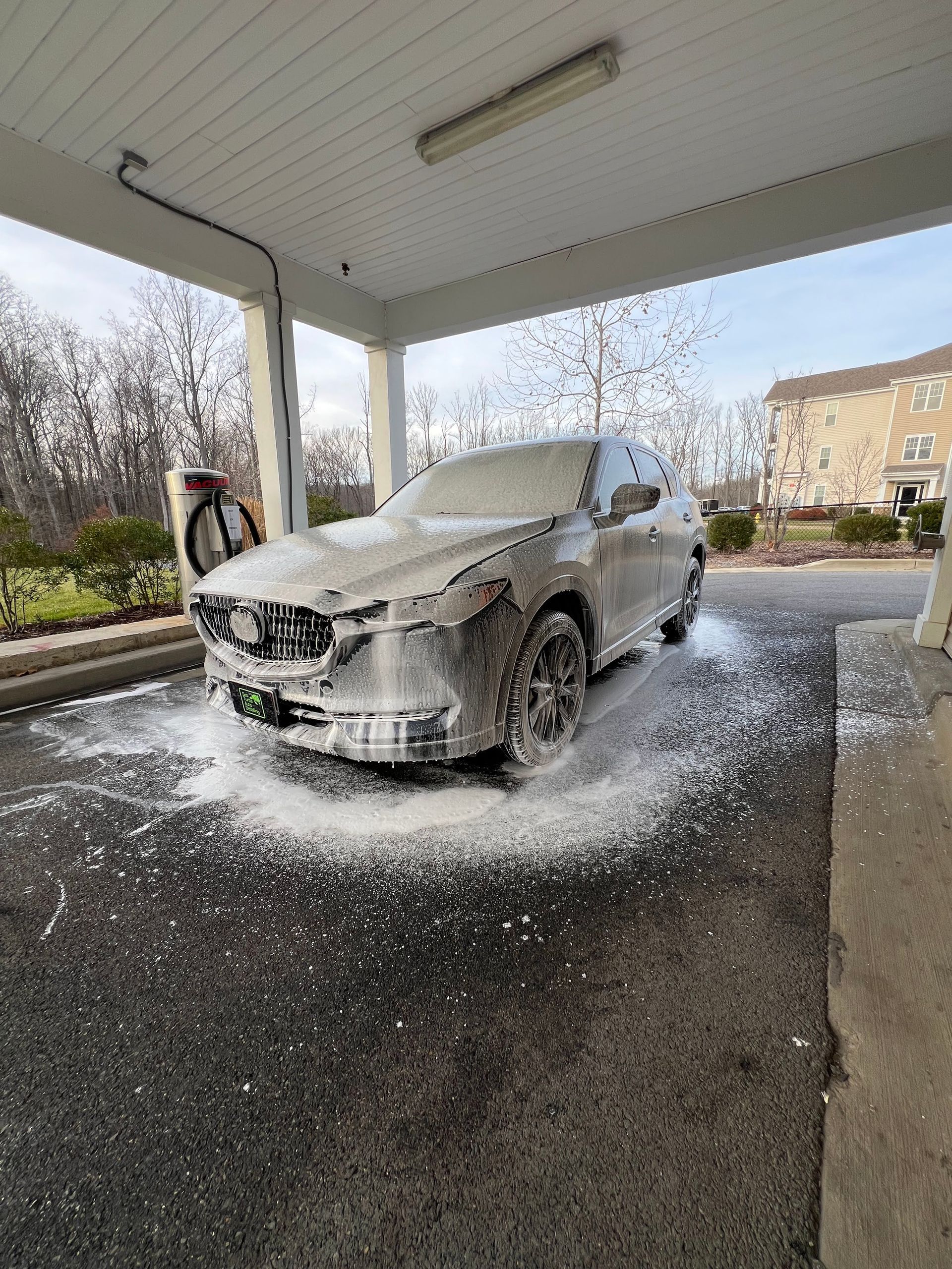 A car is covered in foam at a car wash .