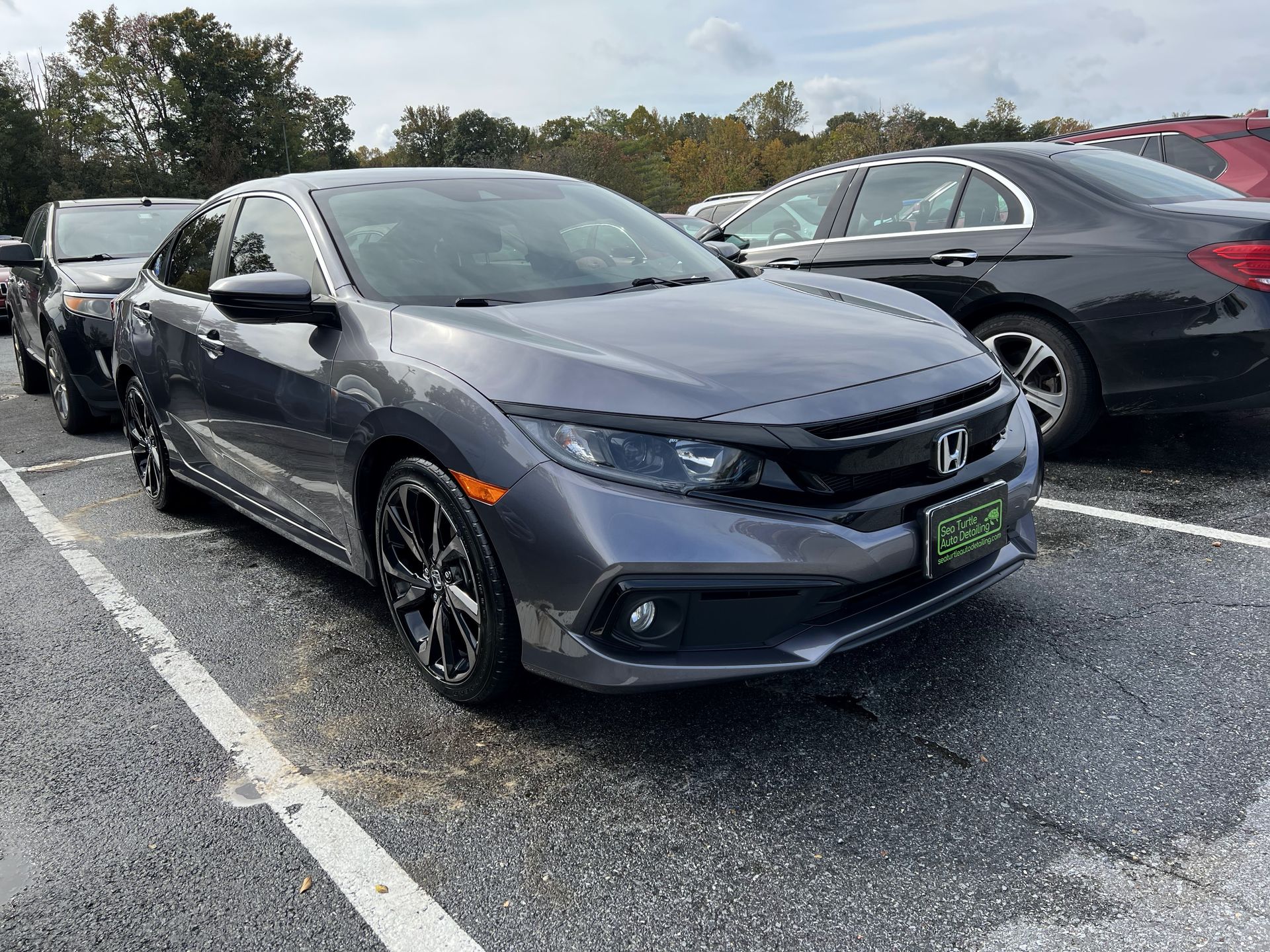 a row of cars are parked in a parking lot .