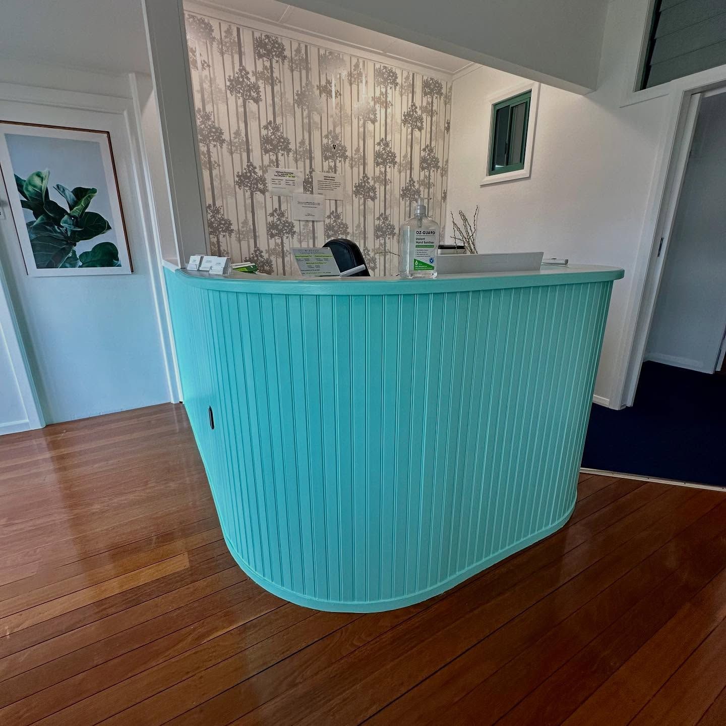 Reception Area With a Turquoise Desk and Wooden Floor — CPAINT in Forster, NSW