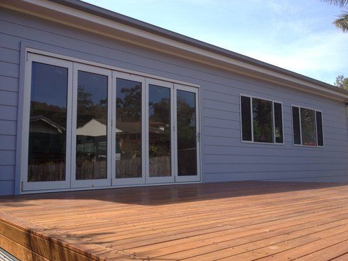 House With A Wooden Deck And Sliding Glass Doors — CPAINT in Forster, NSW