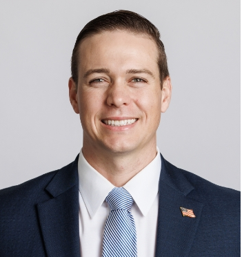 a man in a suit and tie with an american flag pin