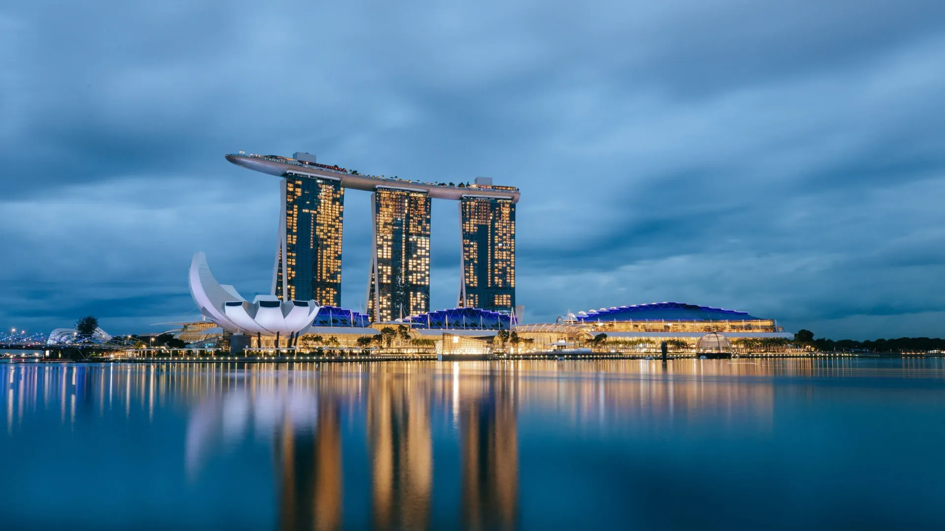 Marina Bay Sands hotel complex in Singapore at dusk, reflected in the water.
