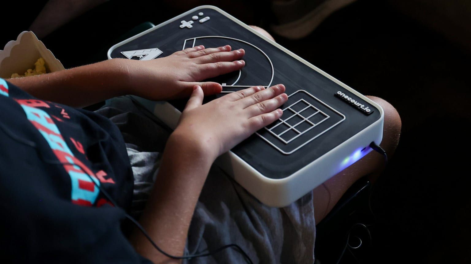 a person using the onecourt system for feeling a baseball game