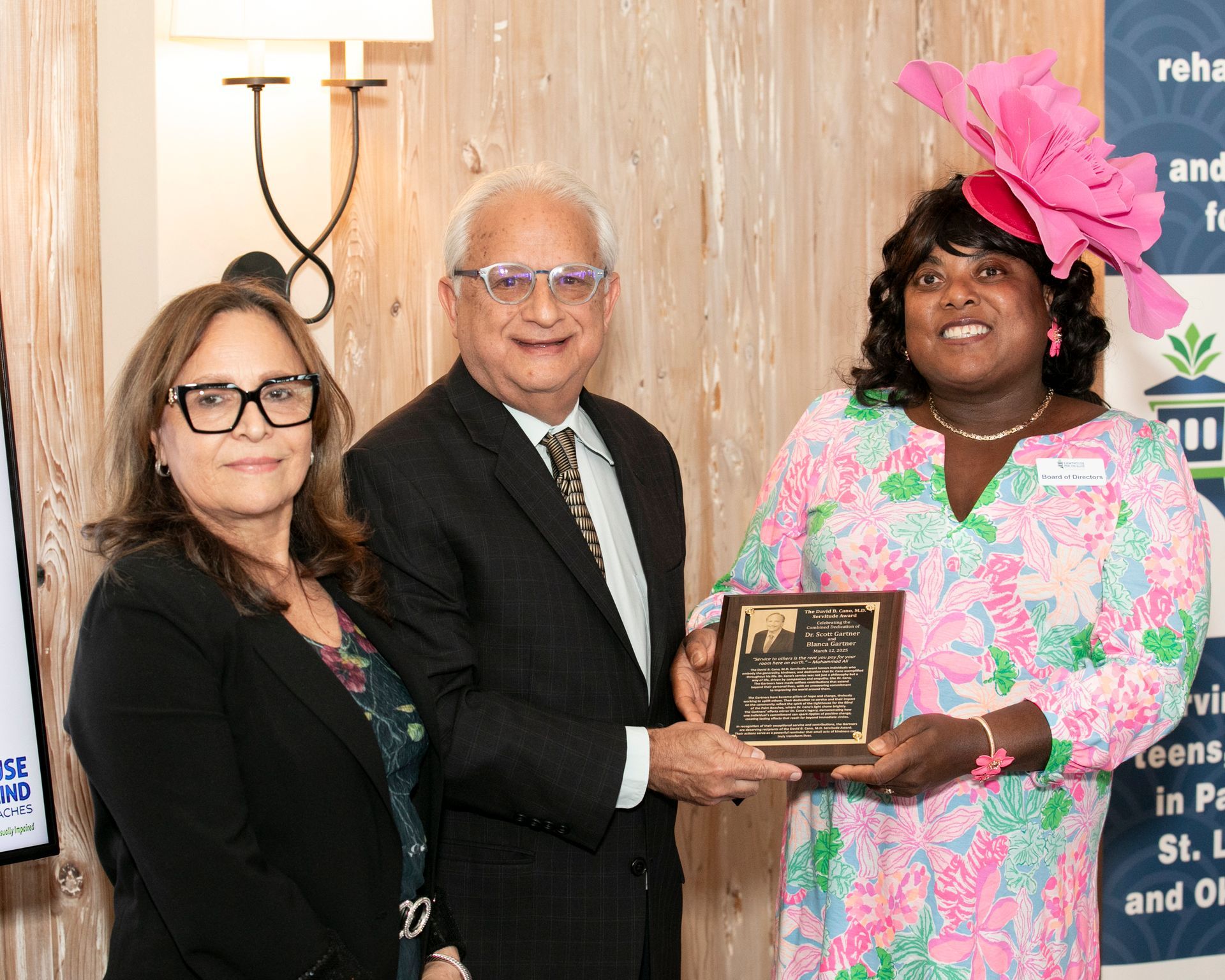 Dr. Scott Gartner and Blanca Gartner receiving an award from Carmencita Mitchell