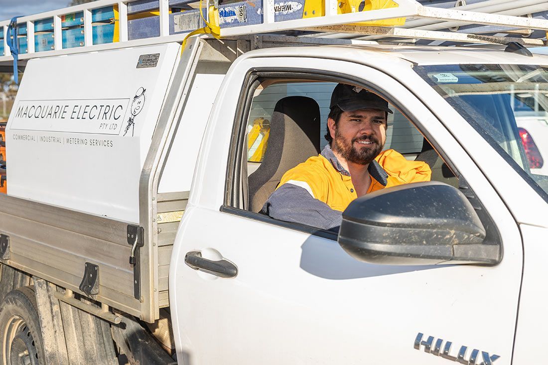 A Man is Sitting in the Driver's Seat of a White Truck — Macquarie Electric in Dubbo, NSW