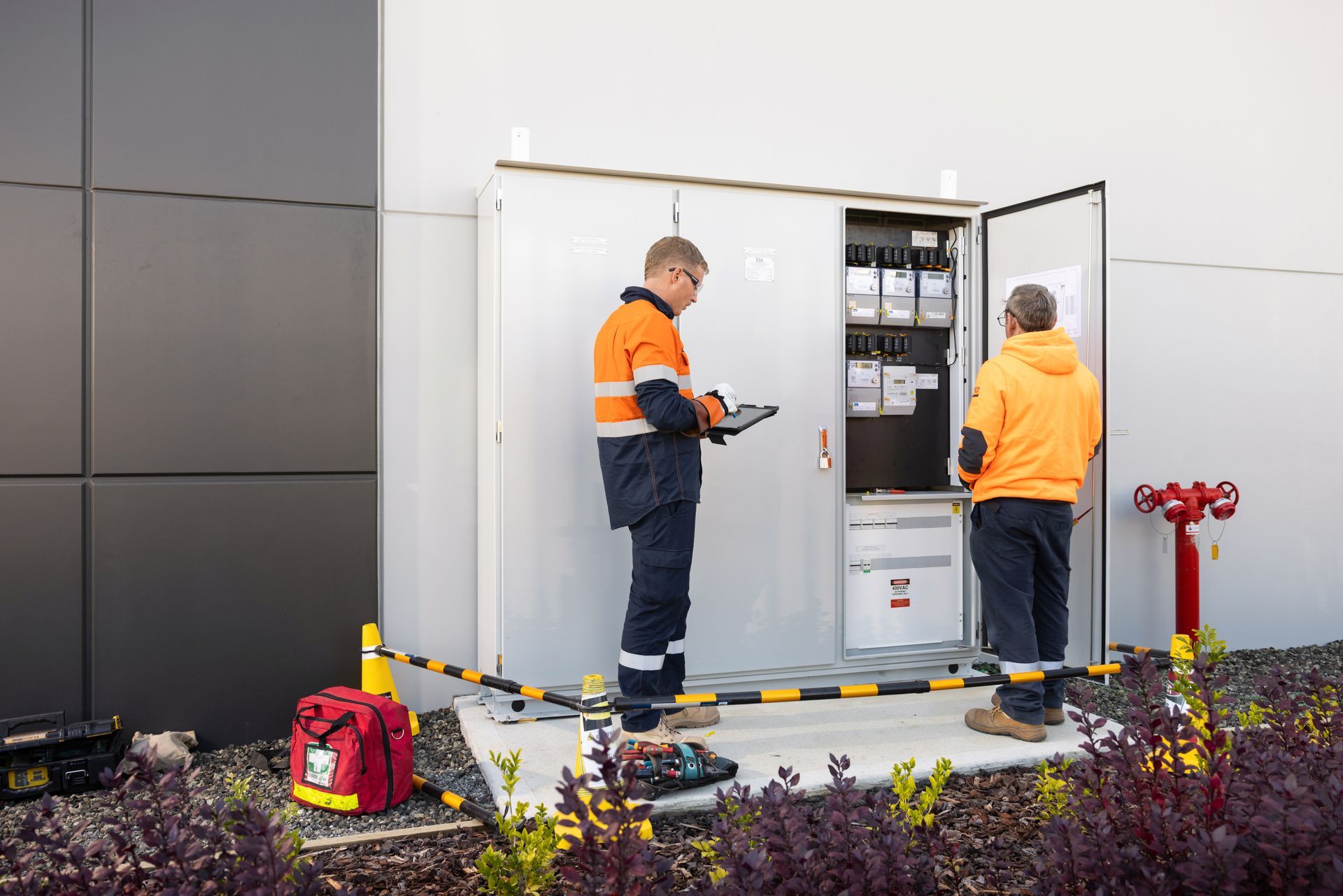 A Group of Men Are Standing in Front of a Building — Macquarie Electric in Dubbo, NSW