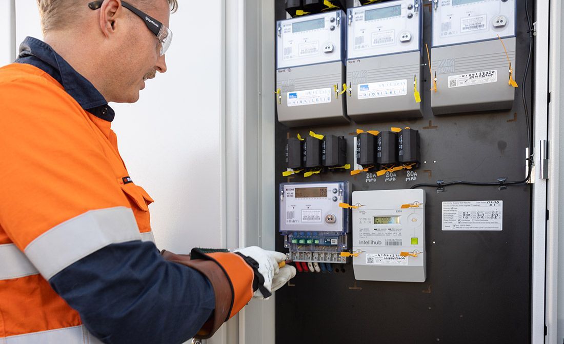 A Man is Working on an Electrical Panel — Macquarie Electric in Forbes, NSW