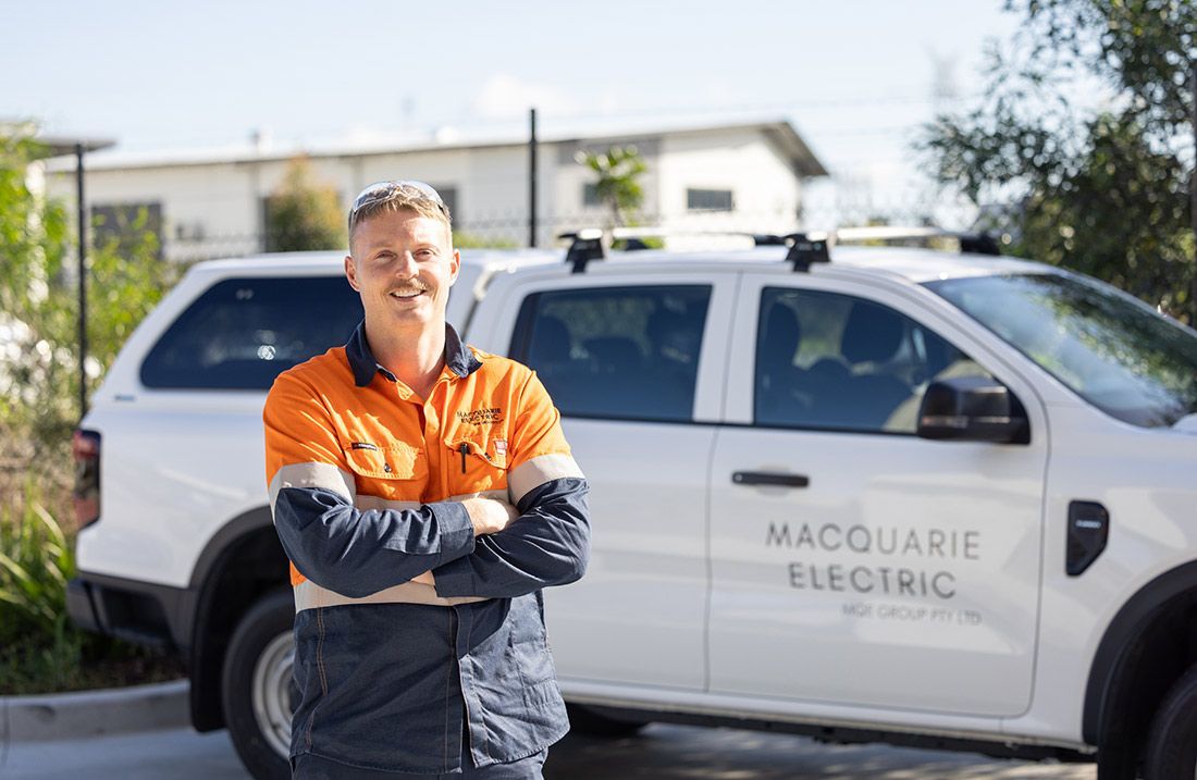 A Man is Standing in Front of a Macquarie Electric Truck — Macquarie Electric in Brisbane, QLD