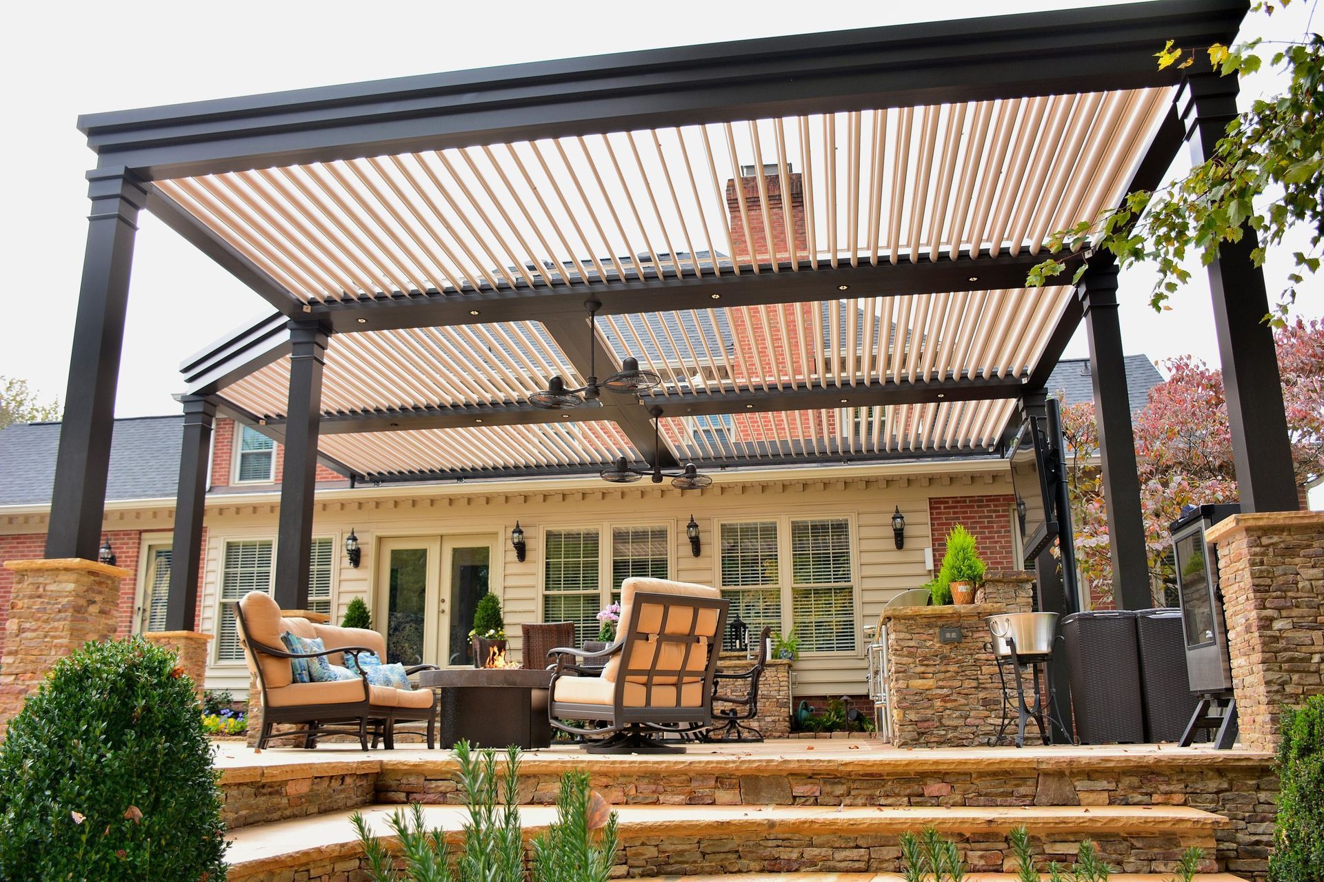 A large patio with a pergola and a lot of furniture.