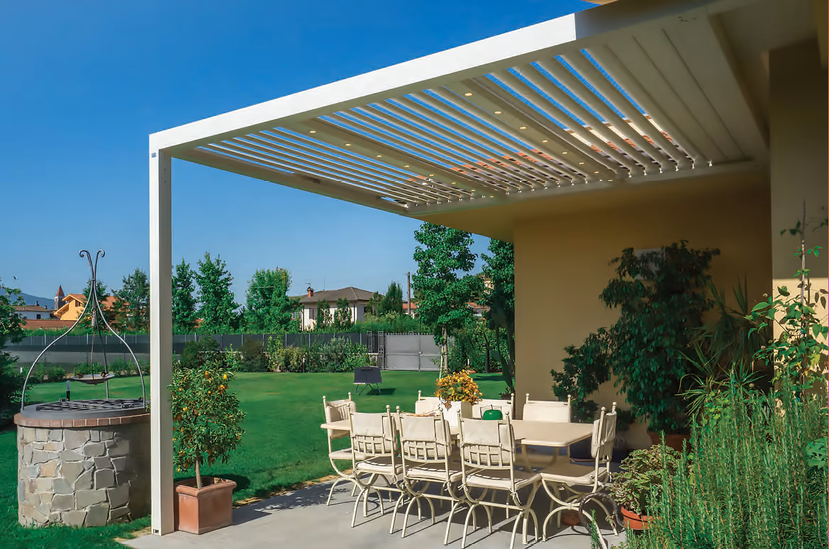 Scenic outdoor view of a pergola adorned with lush greenery, sheltering a charming dining table set underneath.