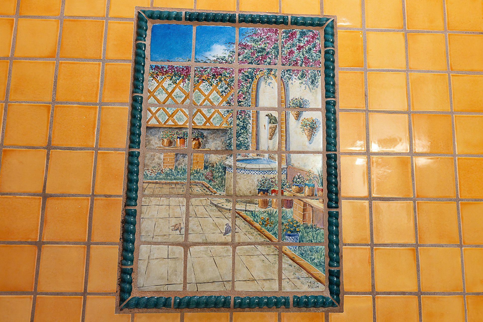 Tile mural of a window overlooking a colorful landscape with blue sky and flowering vines.