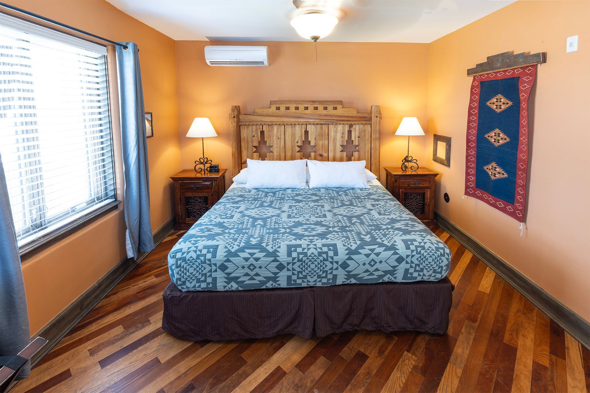Bedroom with a bed, wooden furniture, and orange walls.
