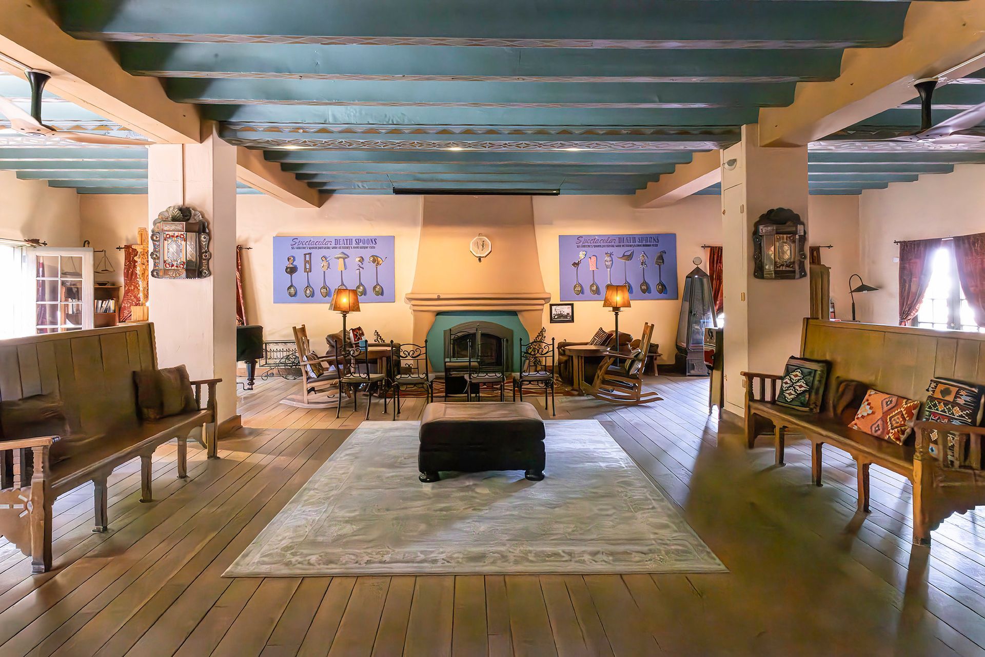 Interior of a room with wooden benches, a fireplace, and a teal ceiling.