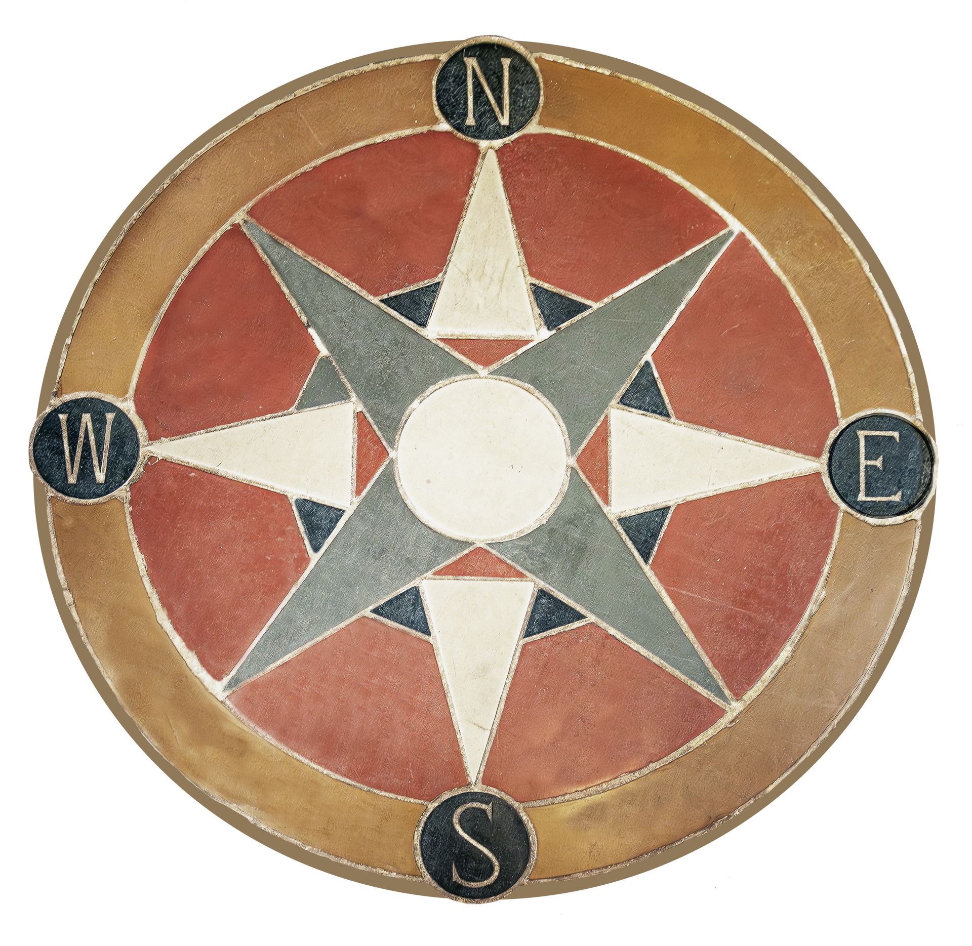 Compass rose design in stone with cardinal directions labeled.