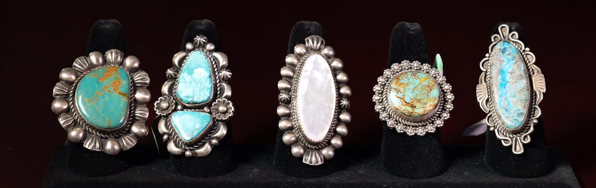 A row of Navajo-made rings featuring turquoise and other stones, all set in sterling silver