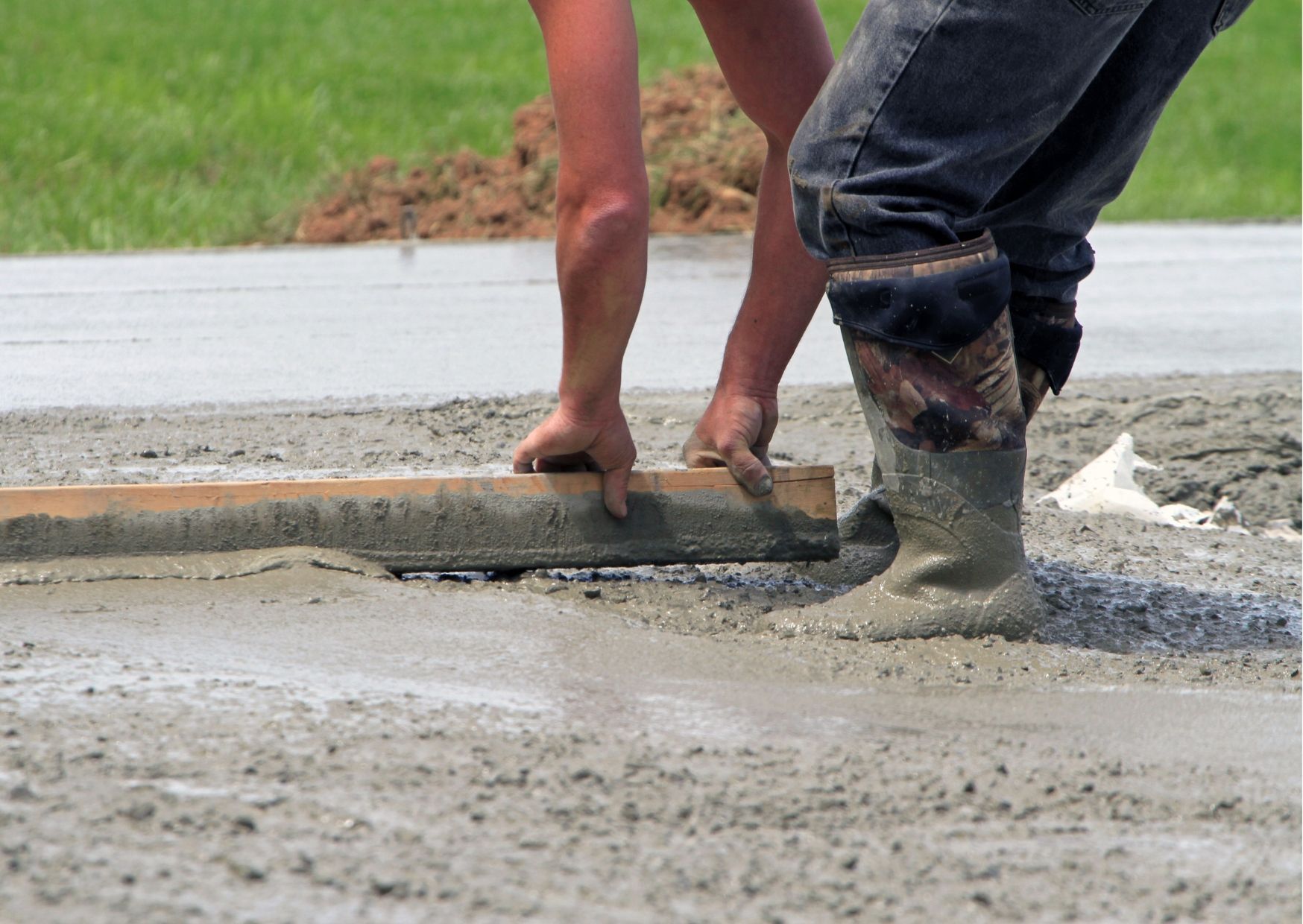 A fire pit is sitting on a gravel patio in front of a brick house.