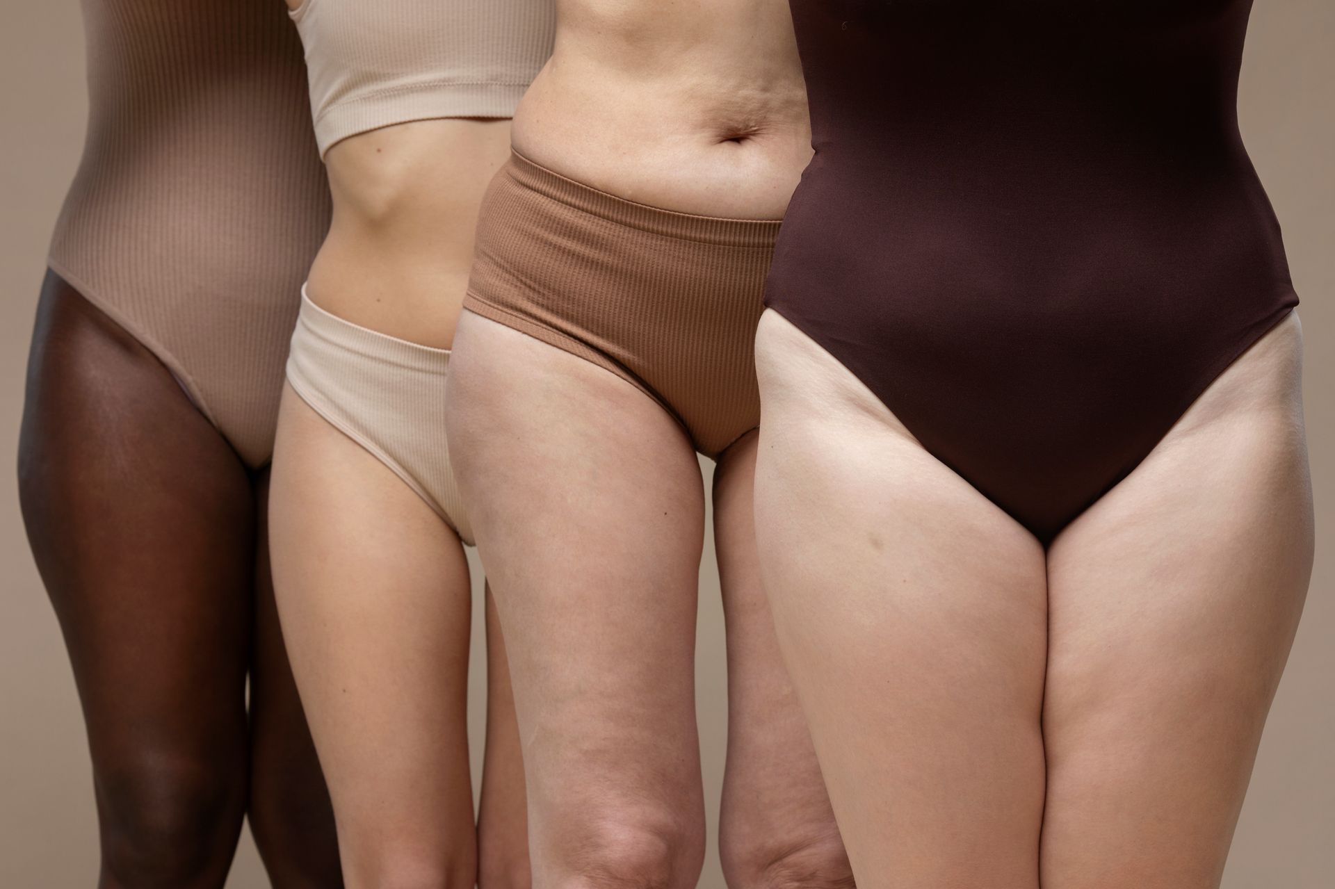 three women standing next to each other wearing different colored underwear