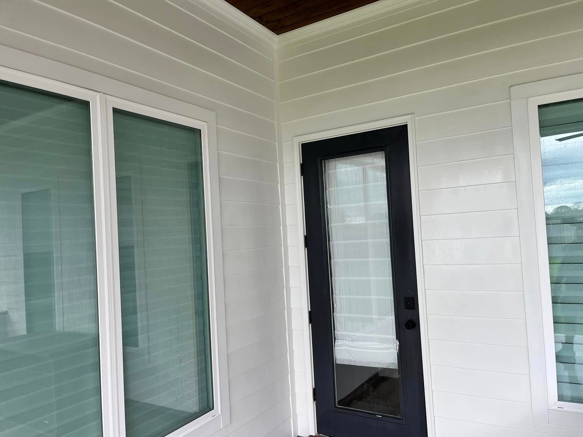 A white house with a black door and windows.