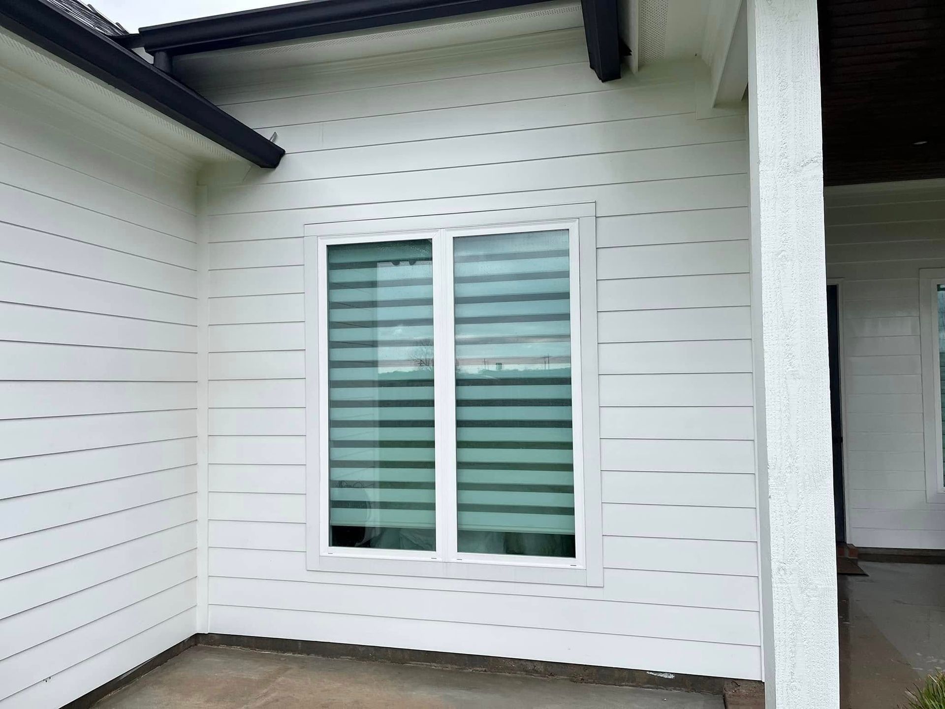 A white house with a large window on the side of it.