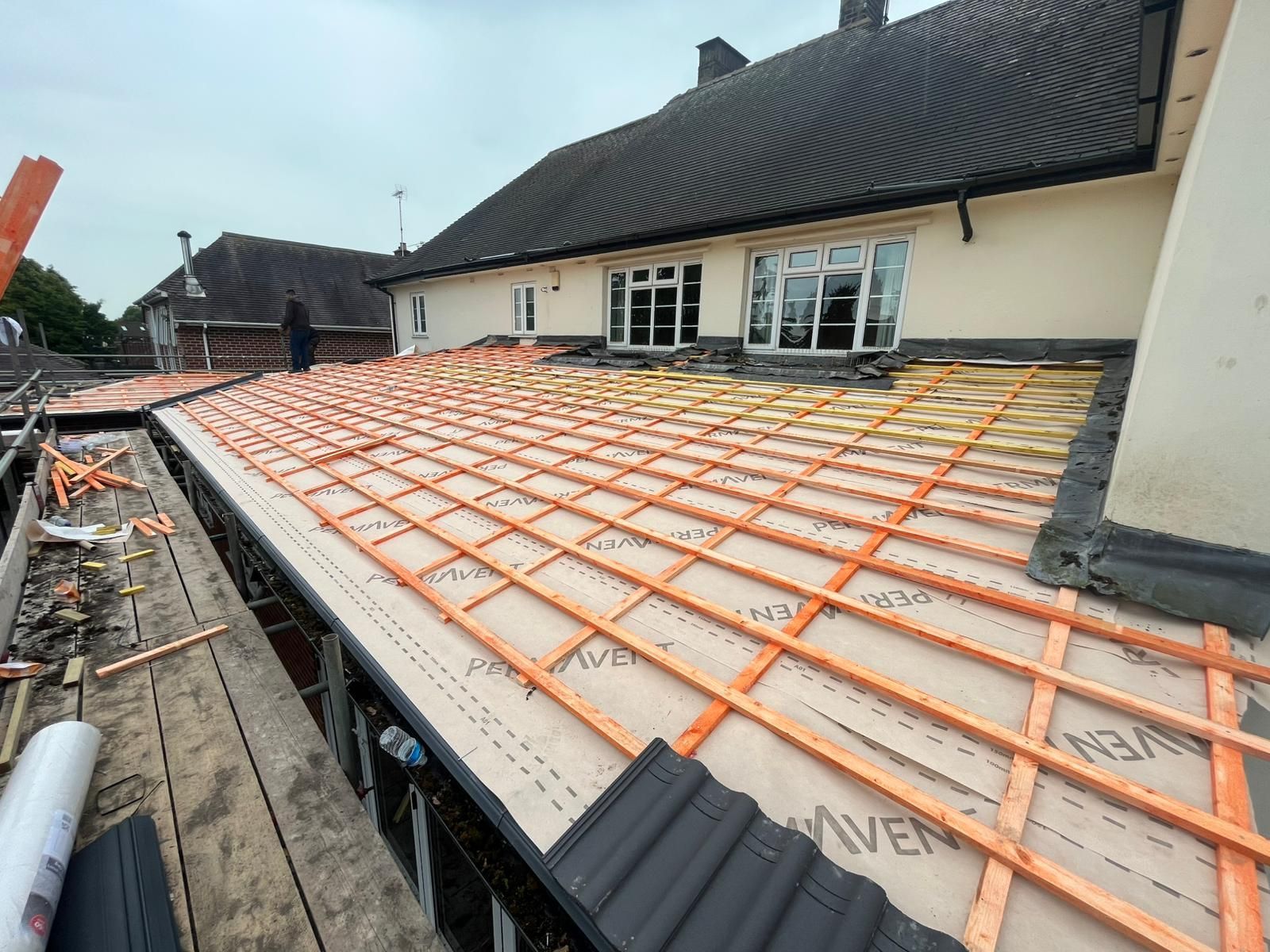 Roof under construction with wooden framework and insulation.