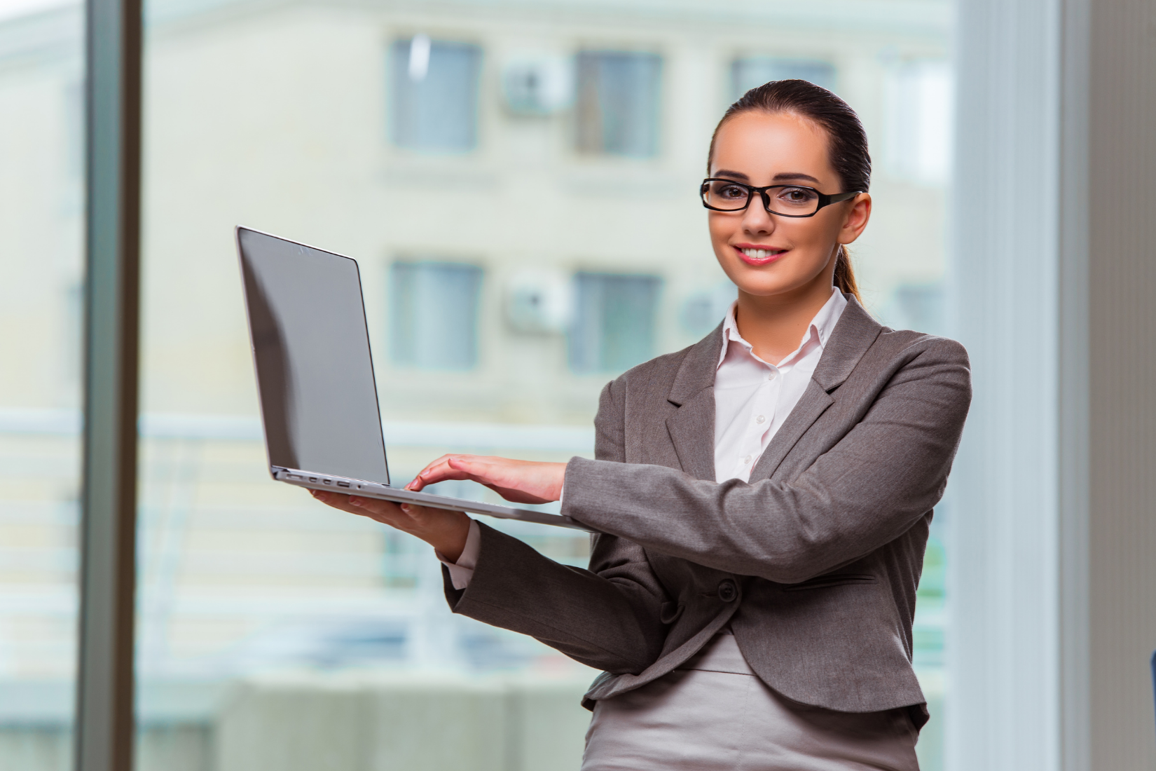 A Virtual Assistant is holding a laptop computer in her hands.