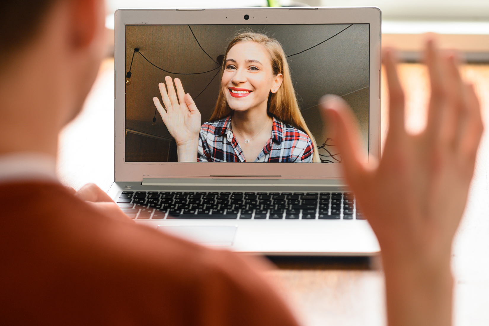A Virtual Assistant is using a laptop computer to have a video call with a client.